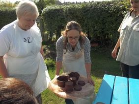 participants collect their pots from the garden ready to work on them in the pottery