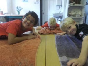 The twin birthday boys and a guest help clean the clay tables inbetween the pottery and the food