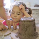 Girl making clay pot for her child minder as a moving on gift