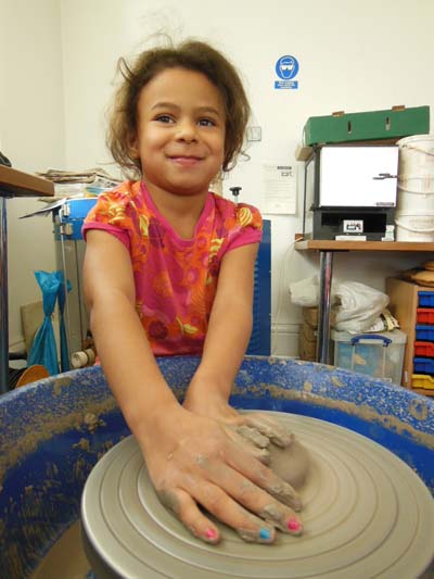 Girl making pottery on the potter's wheel in Bilston Craft Gallery