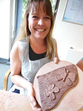 Participant showing finished piece for celebratory tree