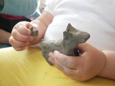 Young Hands Making Clay Dog