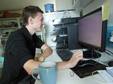 Jack working at the computer for apprenticeship with Eastnor Pottery