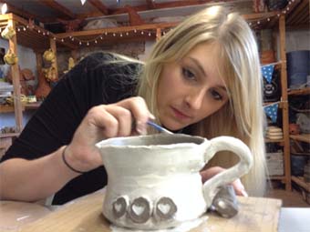 Carefully painting a magnificent pot at Eastnor Pottery
