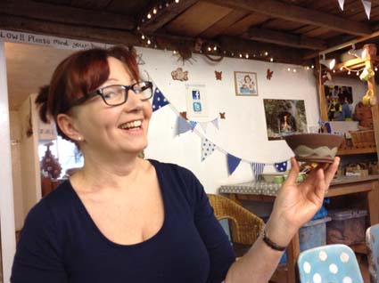 lady pleased with pottery creation made on the potter's wheel