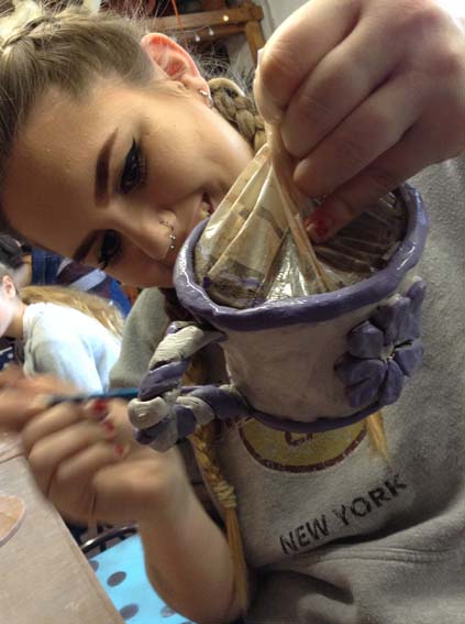 Painting freshly made coil pots at Eastnor Pottery