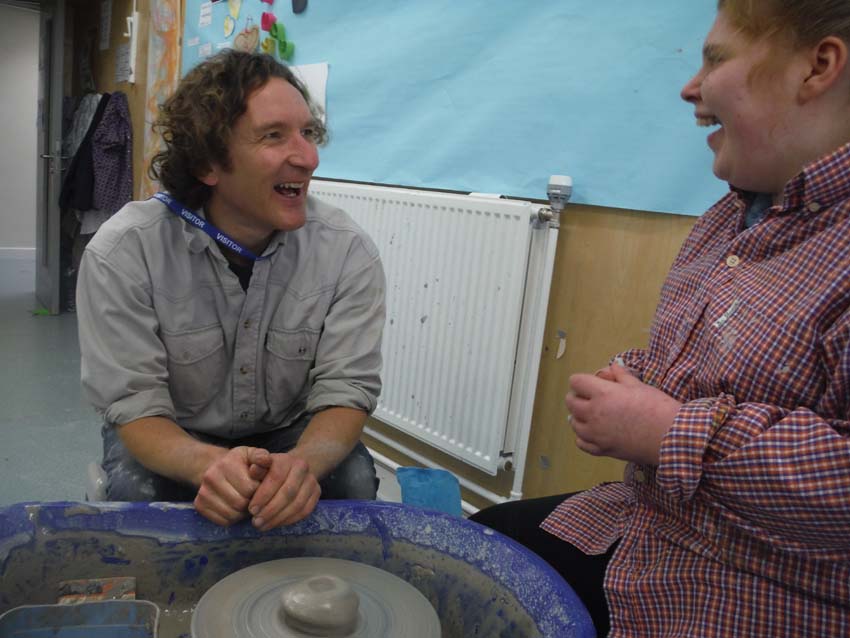 Jon Williams working on the potter's wheel with a student at Sunfield residential School