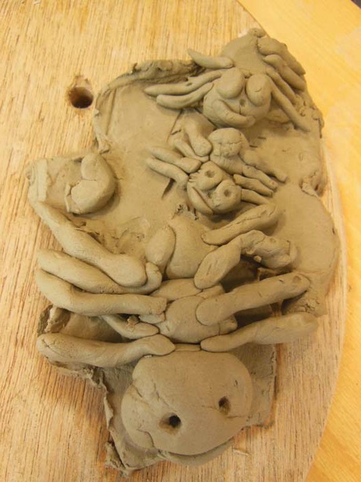 Clay spiders crawling over tile panel piece with Eastnor Pottery