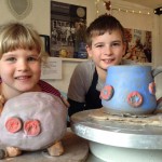 A brother and sister make a pottery piggy bank and wheel thrown mug at Eastnor Pottery as their Christmas present