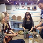 Ethan from eastnro Pottery demonstrates handles to birthday group