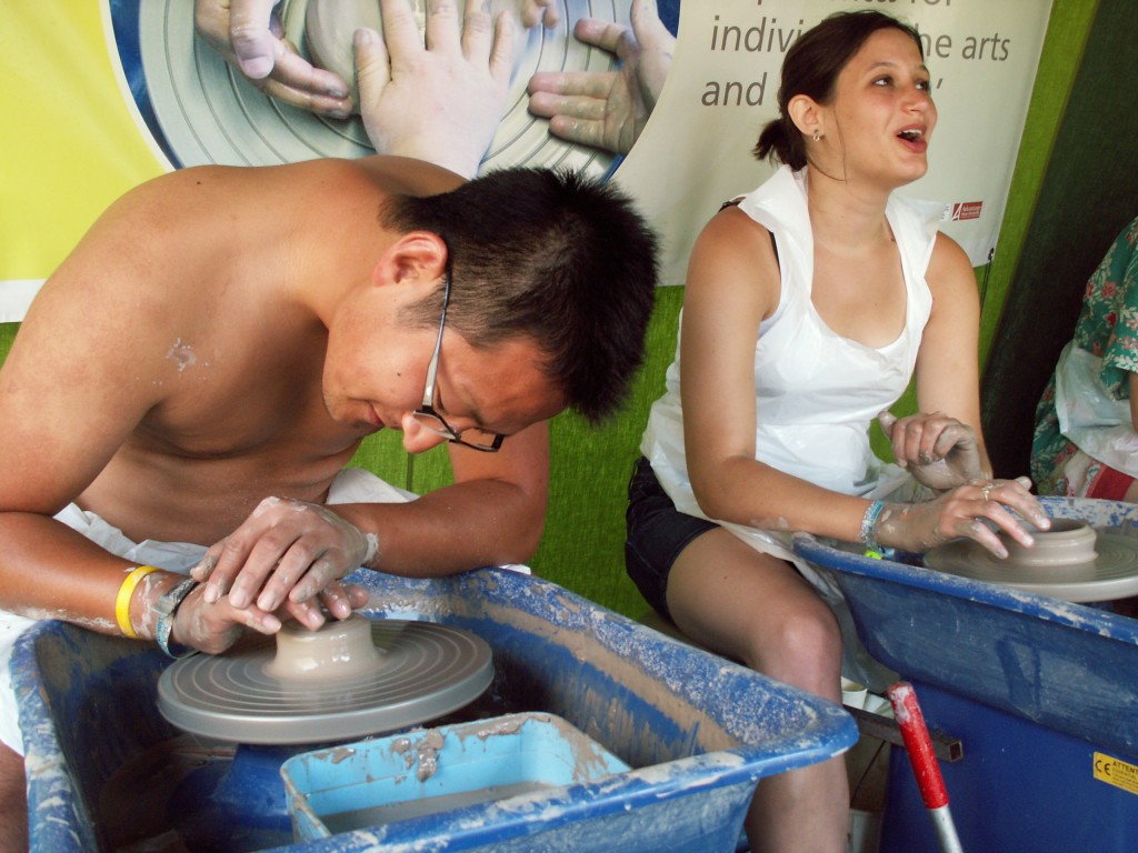 festival goers enjoy making pots on the potter's wheel at music festivals