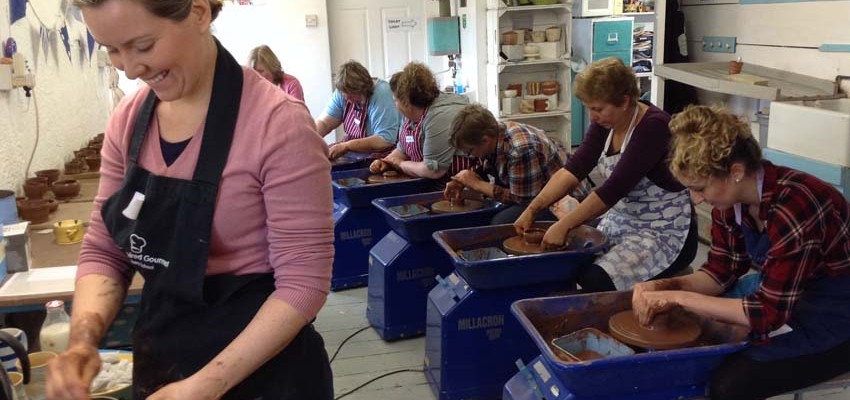 nine first time potter's wheel course participants making pots on the potter's wheel