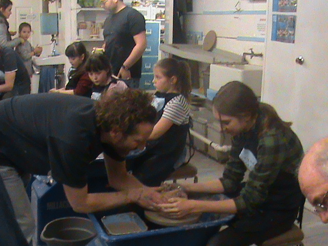 Large family make pots on the potter's wheel