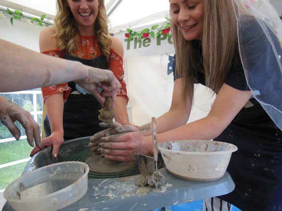 bride to be makes a pot on the potters wheel at  pottery hen party